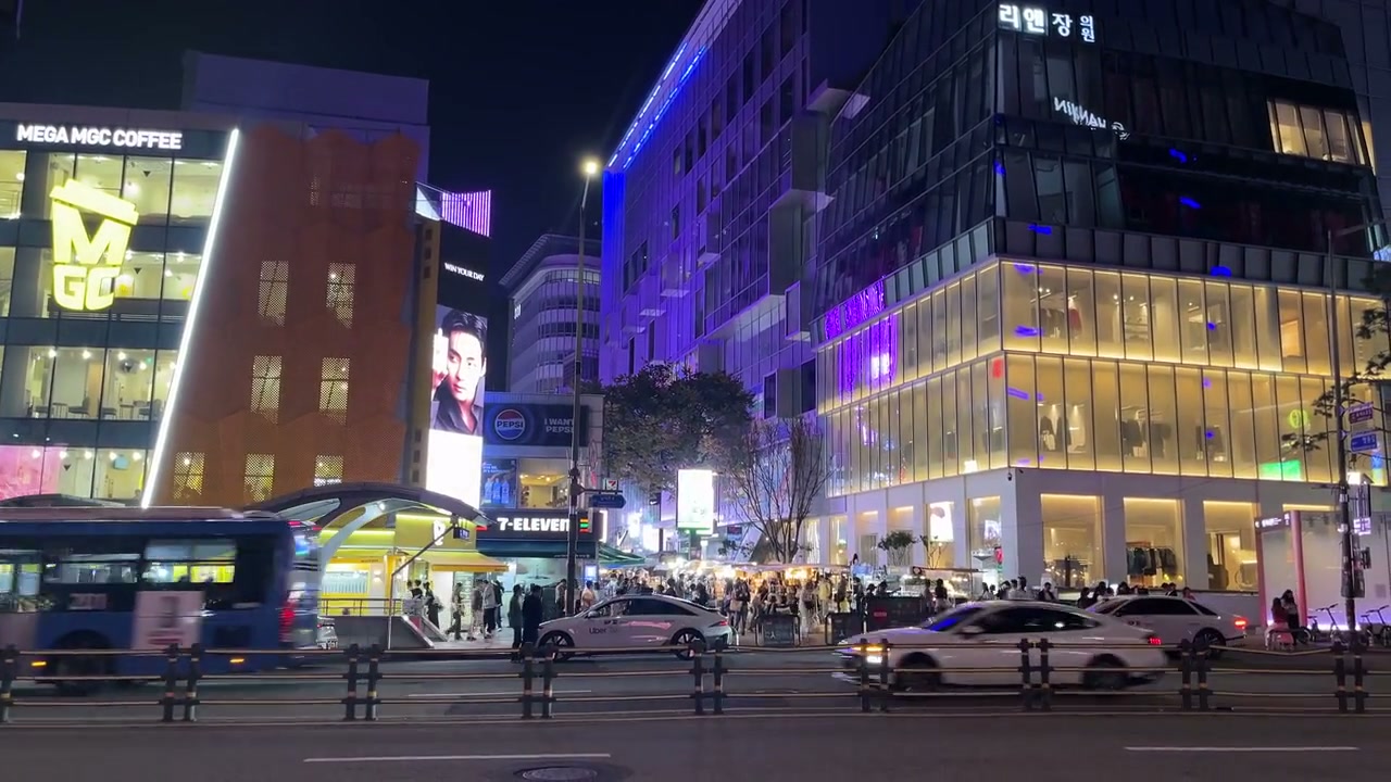대형 전광판과 한글 간판이 빛나는 강남대로 밤거리, 오가는 차량과 인파
